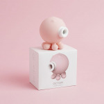 Sugador de clitóris polvinho Octopi em cima da embalagem em fundo rosa